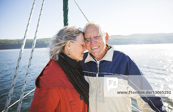 Liebende ältere Frau steht mit Mann in Jacht auf See