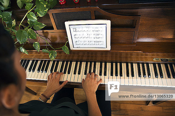 Ausgeschnittenes Bild einer Frau  die zu Hause Klavier spielt