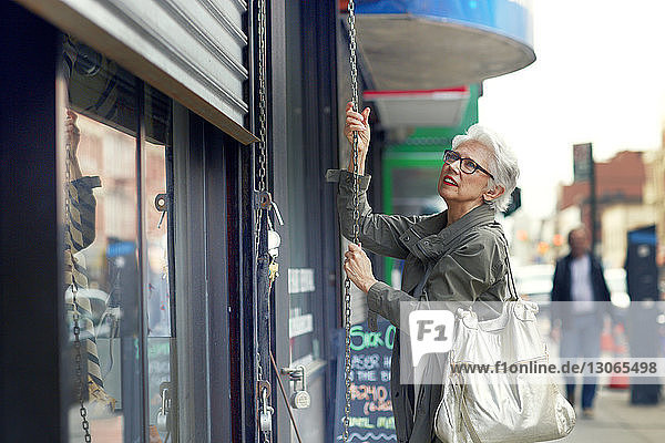 Woman opening store shutter