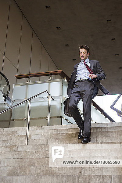 Geschäftsmann bewegt sich die Gebäudetreppe hinunter