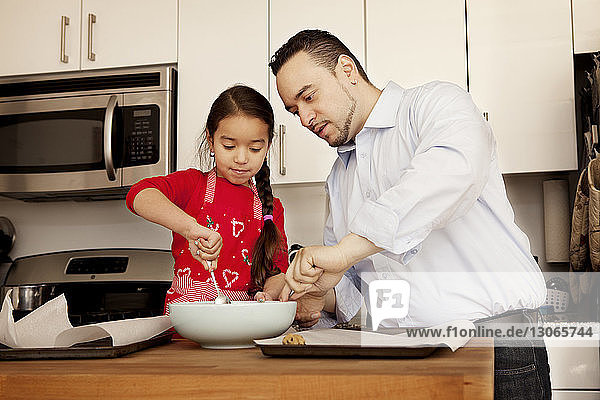 Vater und Tochter bereiten zu Hause Essen vor