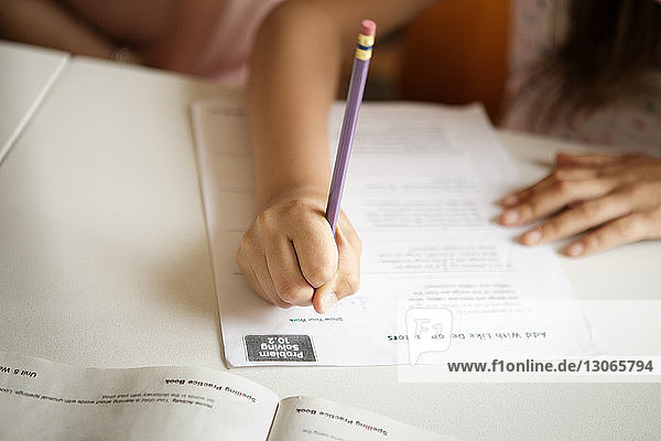 Ausgeschnittenes Bild eines Mädchens  das am Tisch lernt