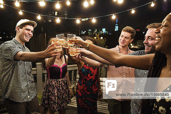 Cheerful friends toasting drinks at party