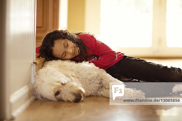 Mädchen und Hund schlafen zu Hause auf dem Boden
