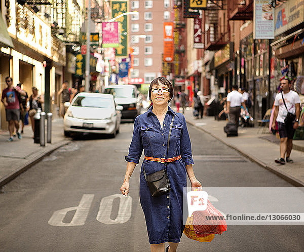 Porträt einer Frau mit Einkaufstaschen auf der Straße in der Stadt