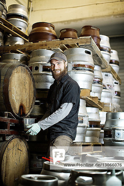 Porträt eines Mannes  der in einer Brauerei Bier vom Fass nimmt
