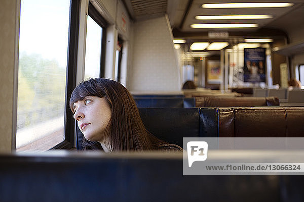 Frau schaut weg  während sie im Zug reist