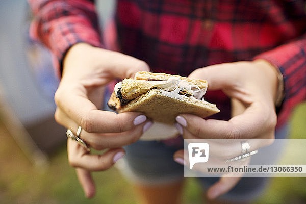 Cropped image of woman holding smore at summer camp