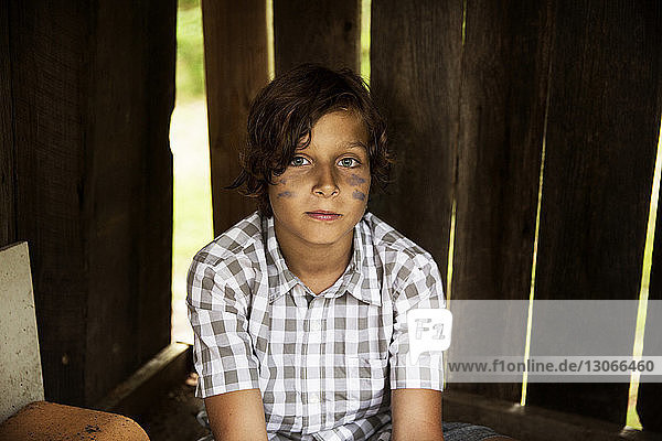Porträt eines Jungen im Baumhaus sitzend