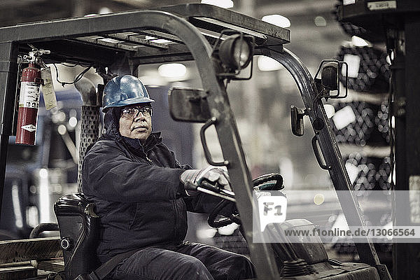 Portrait of man on forklift in factory