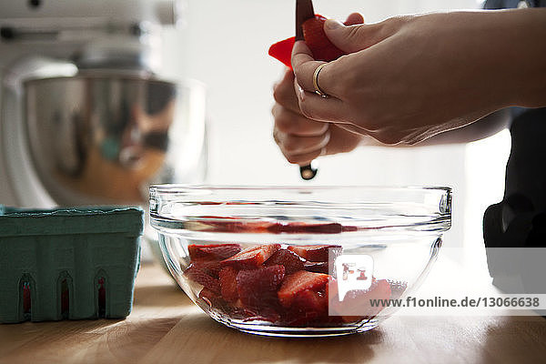 Ausgeschnittenes Bild von Händen  die Erdbeeren schneiden