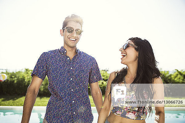 Happy couple standing in backyard against clear sky