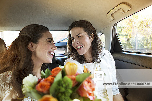 Glückliches lesbisches Hochzeitspaar im Auto