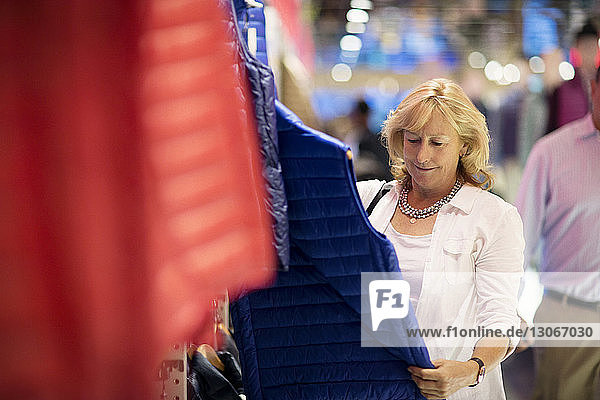 Glückliche Frau beim Einkaufen im Bekleidungsgeschäft
