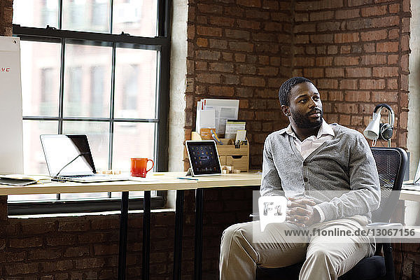 Businessman looking away while sitting in office