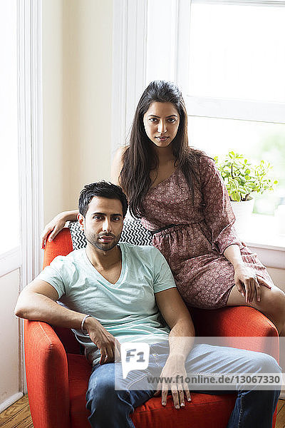 Porträt eines Paares  das zu Hause auf einem Sessel sitzt