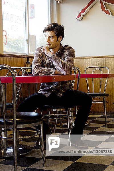 Nachdenklicher Mann sitzt im Cafe
