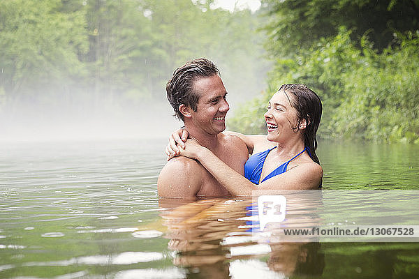 Happy couple swimming in lake