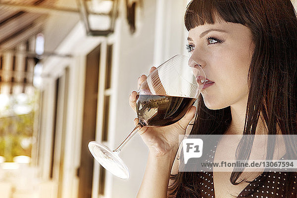 Frau schaut weg  während sie Rotwein trinkt