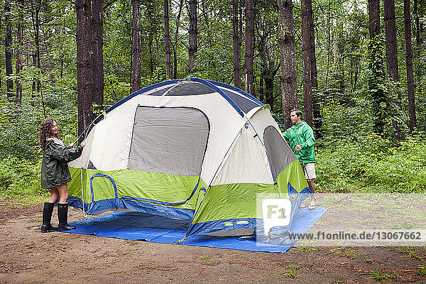 Friends preparing tent in forest