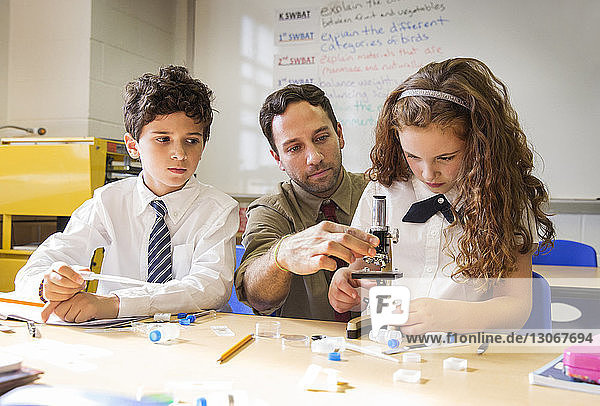 Lehrer hilft Schülern beim wissenschaftlichen Experiment im Labor