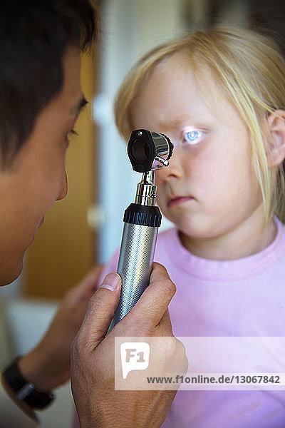 Arzt untersucht das Auge des Mädchens