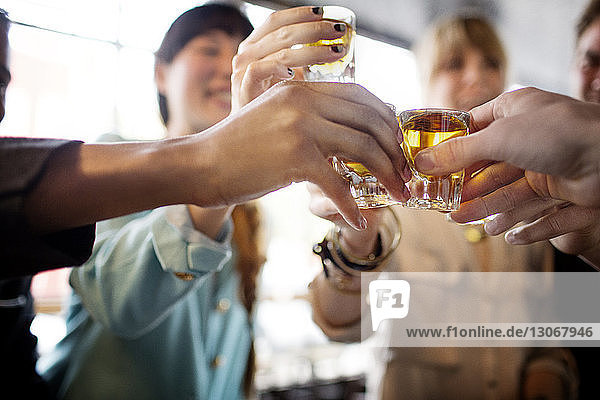 Friends toasting tequila shots in bar