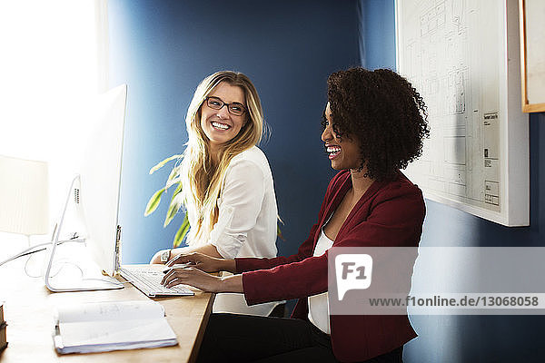 Lächelnde Geschäftsfrauen  die im Büro arbeiten