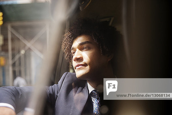 Businessman looking away while sitting in car