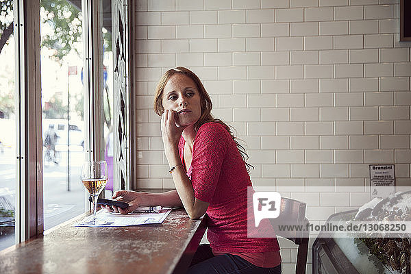 Woman looking away while sitting in restaurant