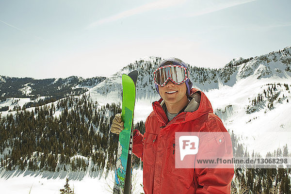 Porträt eines Mannes mit Skibrille auf schneebedecktem Berg stehend