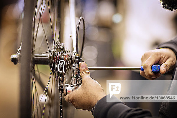 Cropped image of man repairing bicycle in workshop