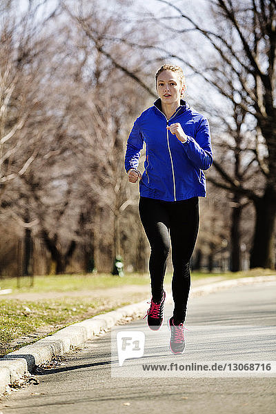 Woman jogging on road in park