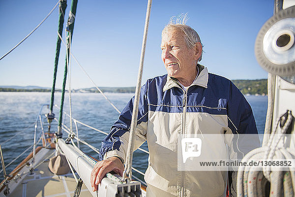 Nachdenklicher älterer Mann steht in Jacht auf See