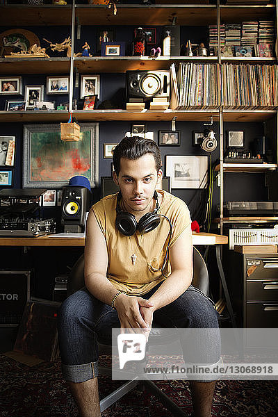 Portrait of DJ sitting at recording studio