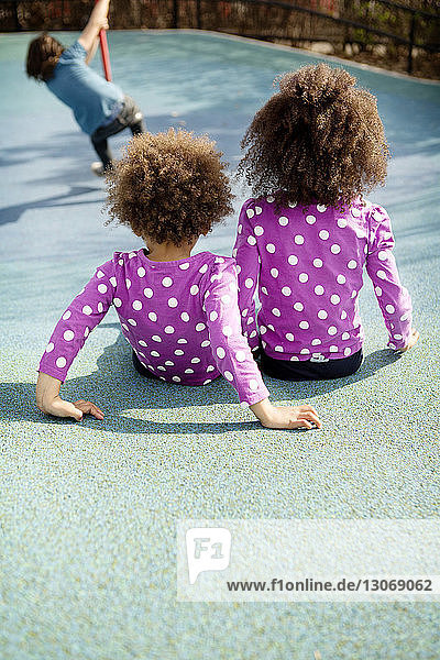Rear view of children sitting in playground