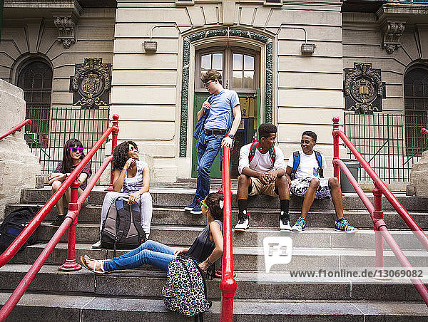 Students resting on steps at entrance of High School