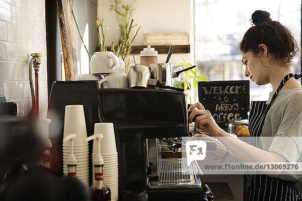 Frau macht Kaffee im Café