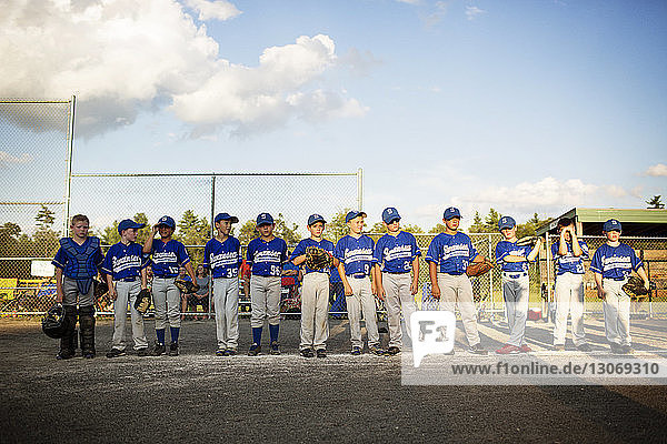Baseball team standing on field against sky