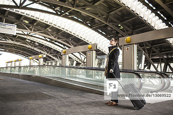 Frau mit Gepäck steht in der U-Bahn-Station