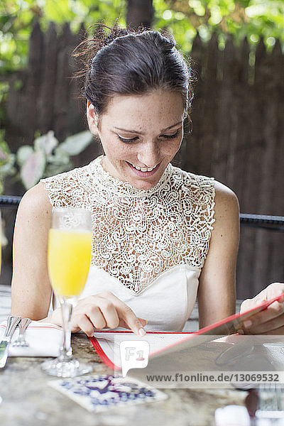 Frau liest Speisekarte  während sie im Restaurant sitzt
