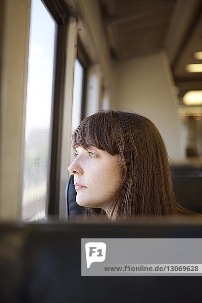 Nachdenkliche Frau schaut weg  während sie im Zug reist