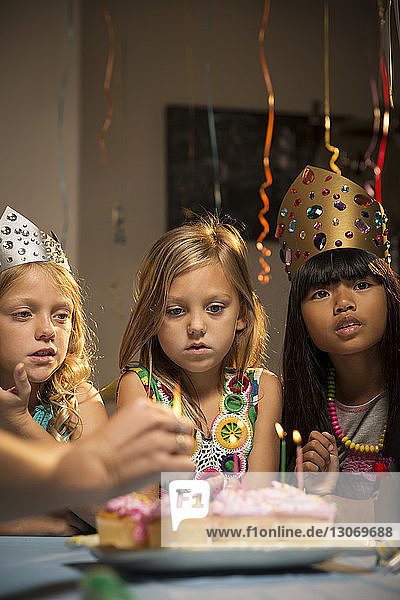 Kinder schauen sich während der Geburtstagsfeier Törtchen an