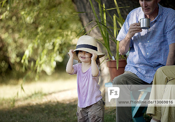 Grandfather looking at girl wearing sun hat
