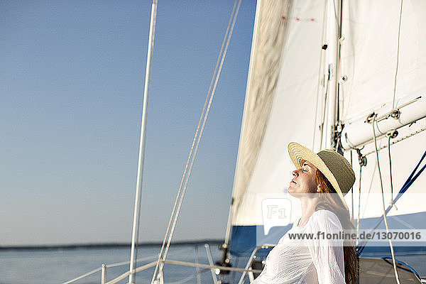 Glückliche Männer halten Seile  während sie auf der Yacht stehen