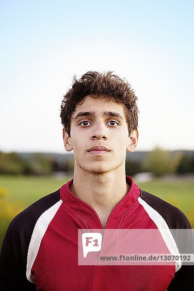 Portrait of confident rugby player standing on field