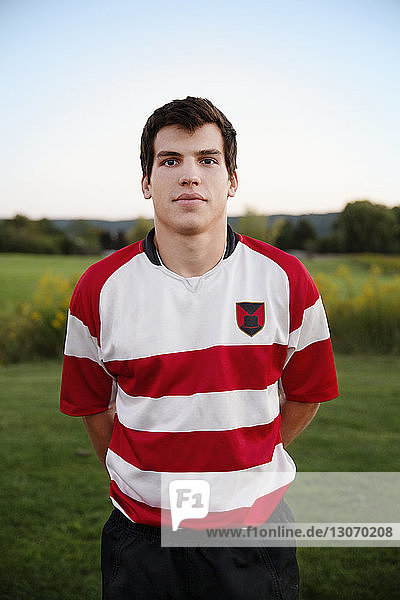 Porträt eines selbstbewussten Rugbyspielers  der mit den Händen hinter dem Rücken auf dem Feld steht
