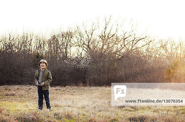 Glücklicher Junge steht auf Grasfeld