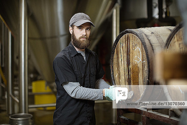 Porträt eines Mannes  der Fässer in einer Brauerei repariert