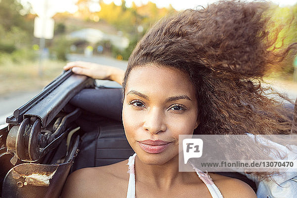 Porträt einer lächelnden Frau  die in einem Cabriolet sitzt